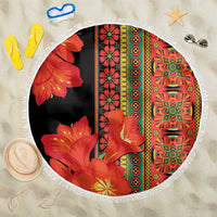 Round beach blanket, black base with red-orange floral pattern and white fringe