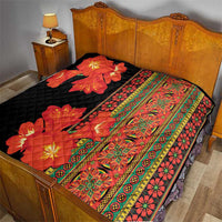 Black quilt on bed with red-orange floral motif and multicolor patterned strip along edge