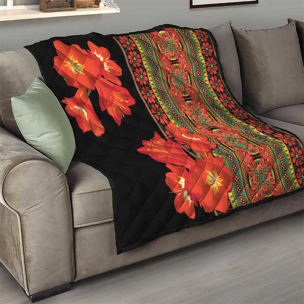 Quilt draped on sofa: black background with red-orange flowers and ornate multicolor stripe