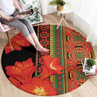 Round area rug with black base and red-orange botanical print bands with circular accents