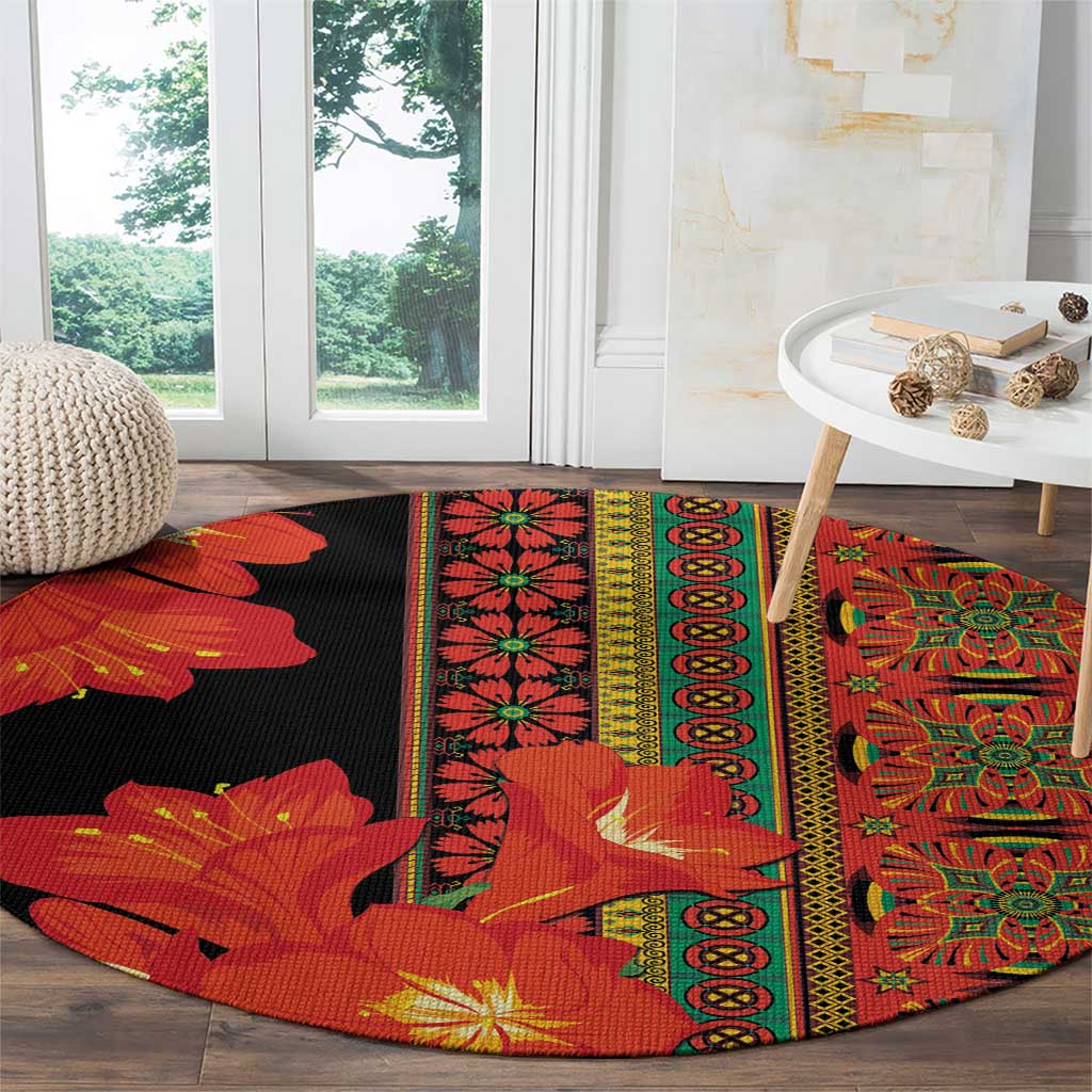 Round area rug with black field and red-orange flower motifs with green-and-gold borders
