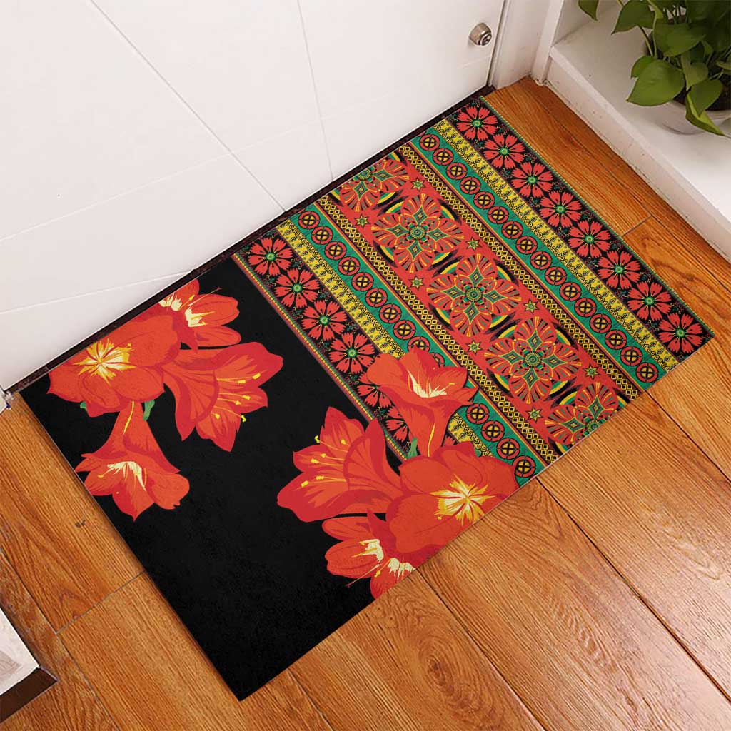 Black rubber doormat with orange flowers and red-green geometric banding