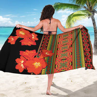 Sarong laid flat: black side with orange-red flowers and bright vertical striped panel