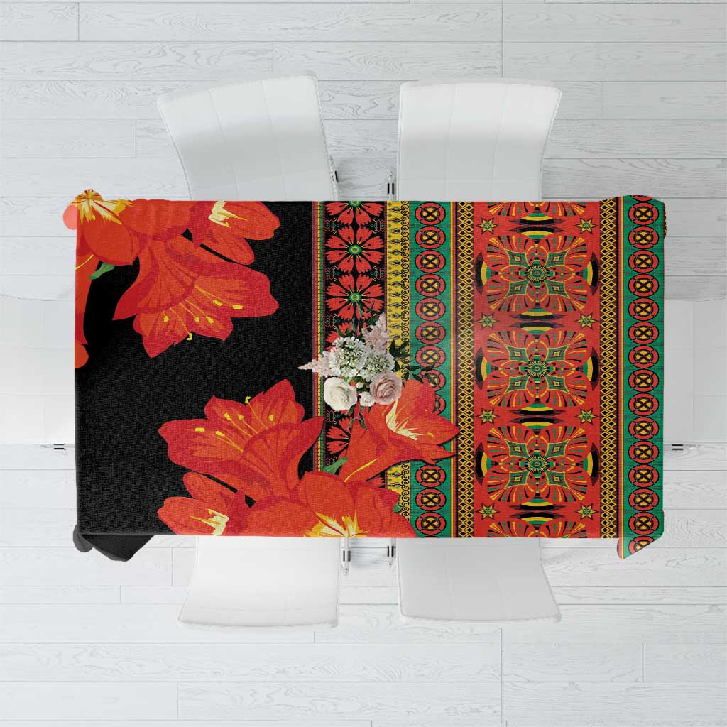 Black tablecloth with red-orange clivia flowers and green patterned border