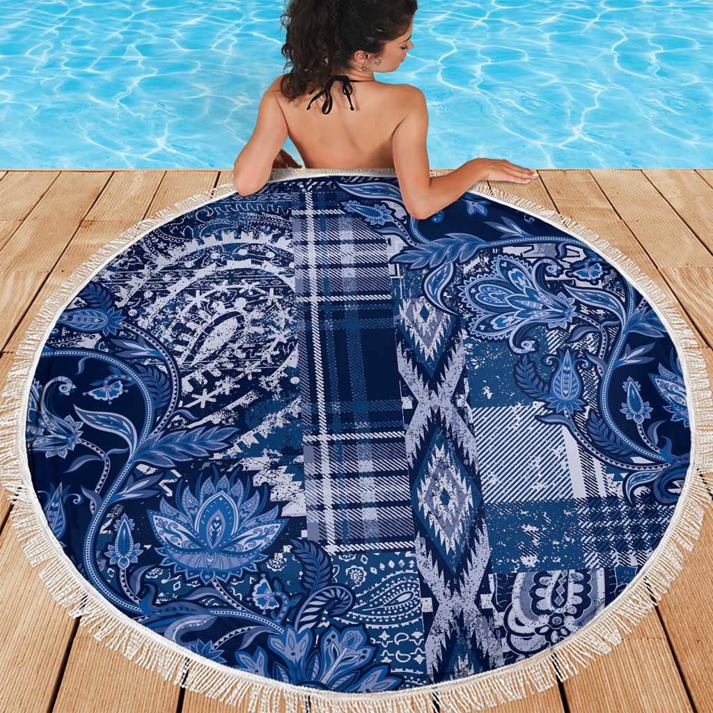 Round blue beach blanket with paisley and floral patchwork pattern, white fringe edge