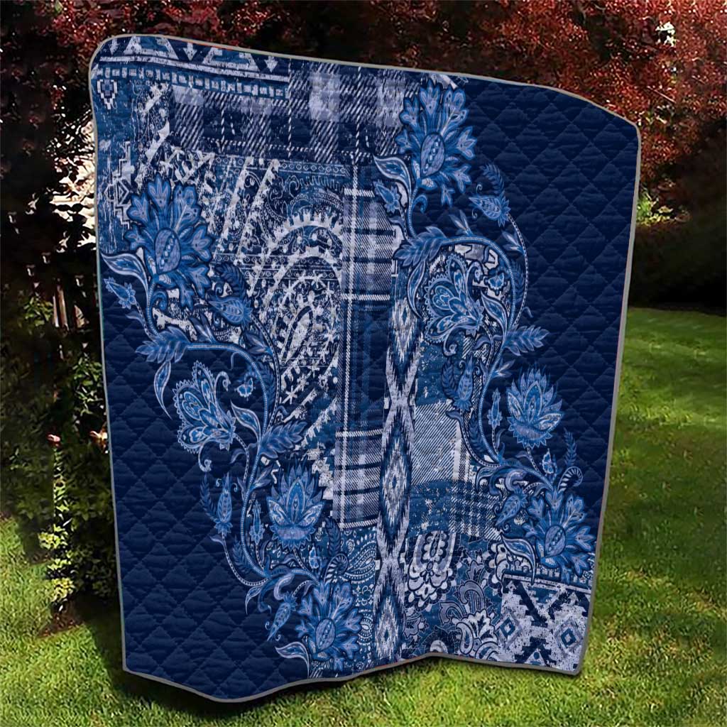 Blue quilt blanket with white paisley and plaid design, diamond stitched texture