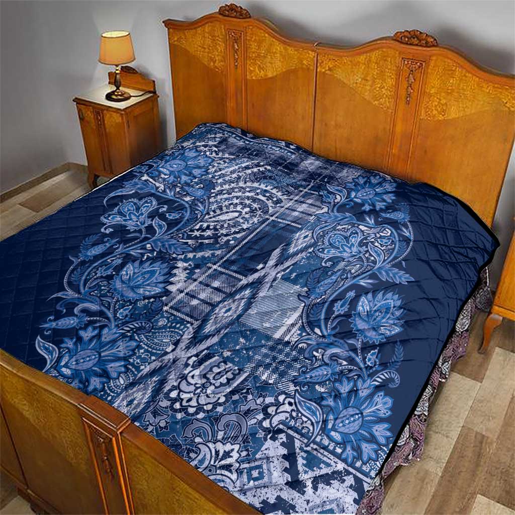 Blue paisley and plaid quilt on bed, diamond-quilted surface with wide coverage