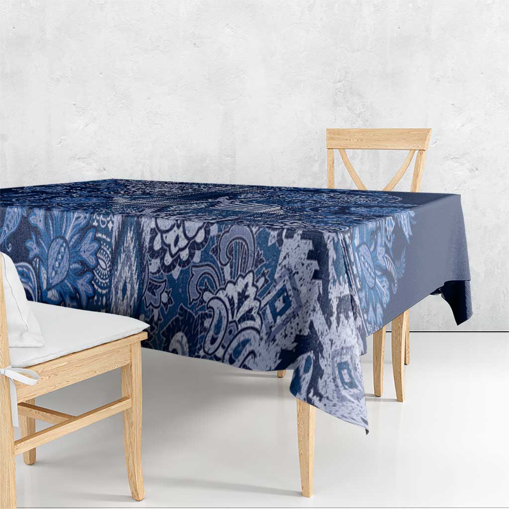 Blue paisley floral tablecloth hanging over table edge with corner drop
