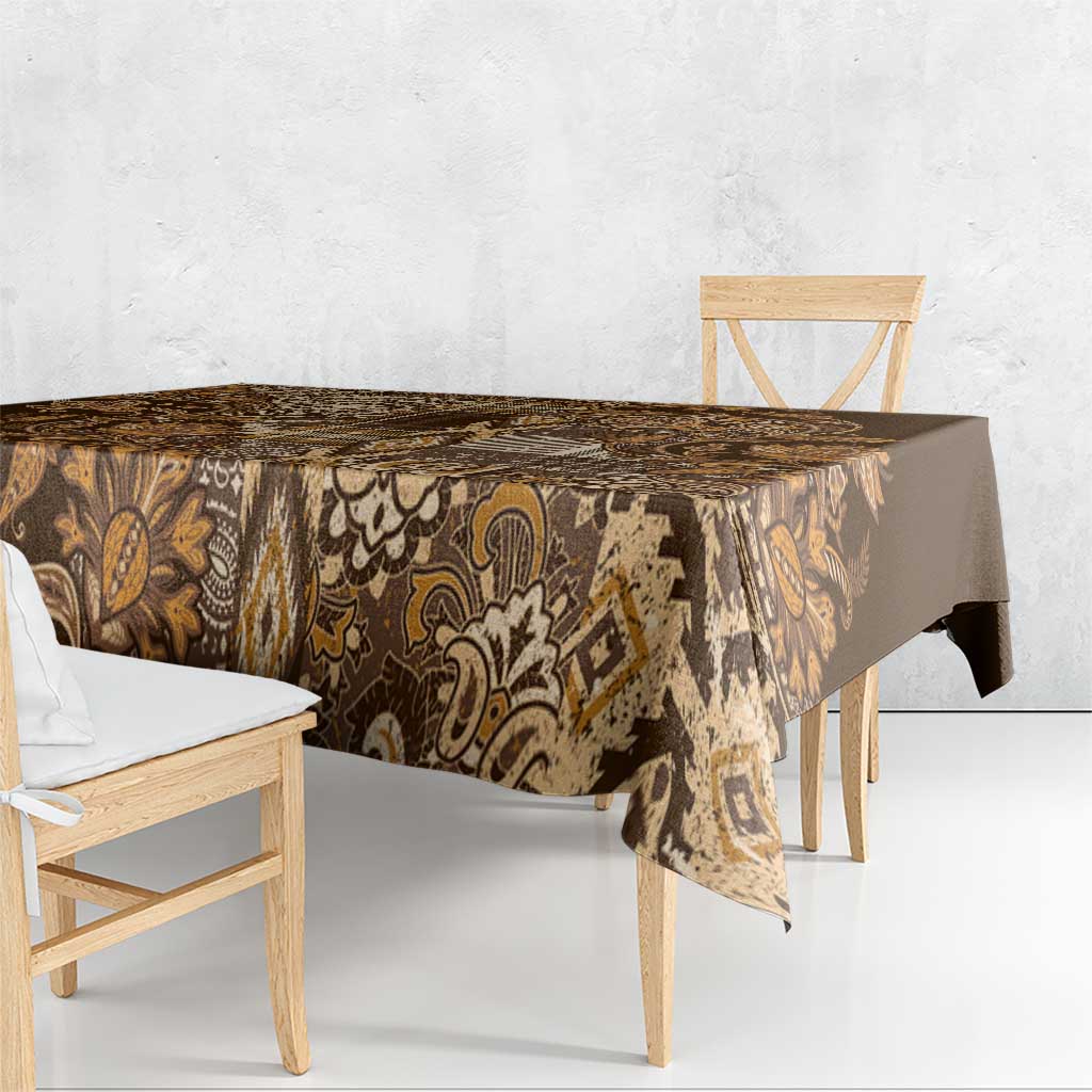 Gold and brown patterned shuka tablecloth draped over dining table edges