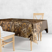 Gold and brown patterned shuka tablecloth draped over dining table edges
