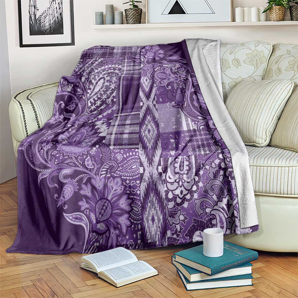 Purple decorative blanket with floral scrollwork and plaid patch pattern, white accents