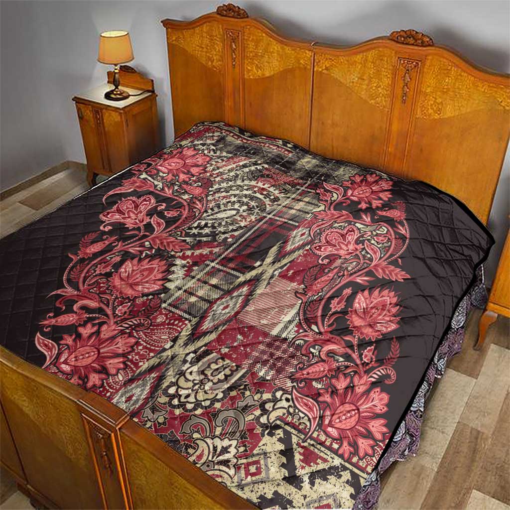 Red floral paisley quilt covering a bed, quilted black backing