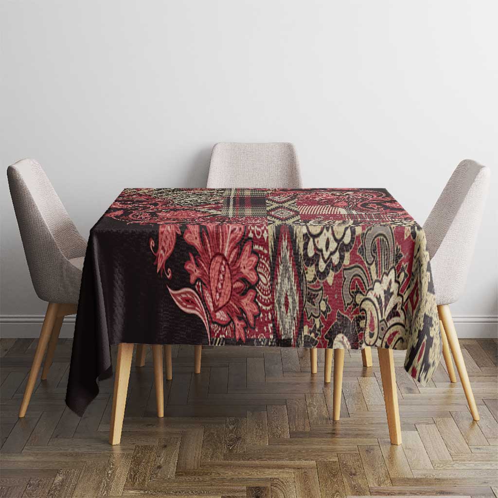 Red, black, and cream paisley floral tablecloth with block-pattern border.