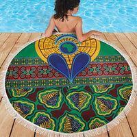 Round green kanga blanket with ornate central sun/eye design and tassel fringe