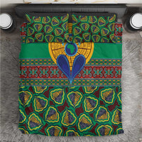 Green kanga-style bedding set top view with yellow emblem and patterned borders