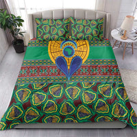Green kanga-style bedding set with bold tribal prints, pillows, and central emblem