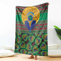 Green African pattern throw blanket featuring a large gold circular emblem with blue shapes