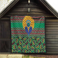 Green quilt with bold kanga borders, central blue-and-yellow emblem, and patterned lower panel