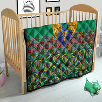 Green quilt with multicolor kanga borders, central blue-and-yellow figure, and diamond quilting