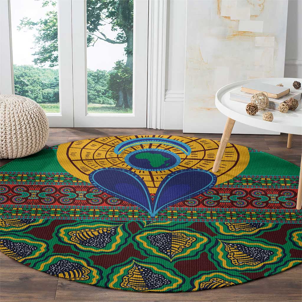 Green round kanga-style rug featuring a yellow medallion center and blue wing-like motifs