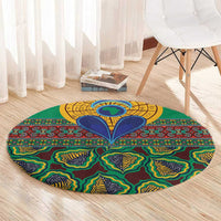 Green round rug with colorful geometric kanga pattern, yellow circular center, and blue accents