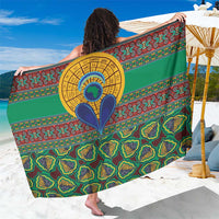 Green kanga-style sarong with bold multicolor circular motif and repeating shapes