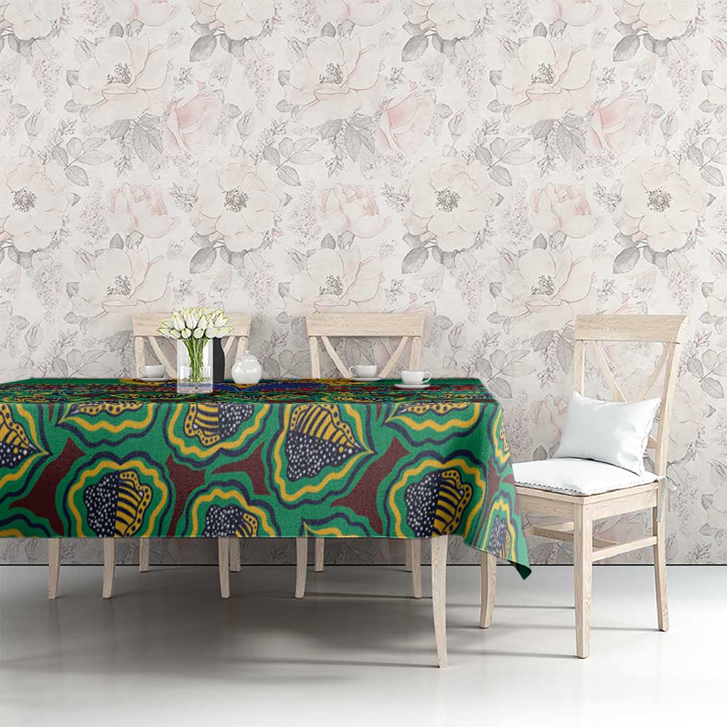 Green African pattern tablecloth with colorful geometric motifs, draped on a dining table
