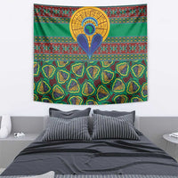 Green kanga tapestry with central sun emblem, teardrop motif, and colorful horizontal stripes