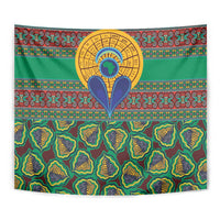 Green kanga-style tapestry featuring a large central sun emblem and repeating seed motifs