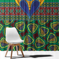 Close-up of green kanga-style window curtain with yellow, blue, and black patterned shapes