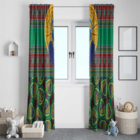 Two green kanga-style curtain panels hanging on a doorway, patterned and draped