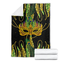 Mardi Gras feather mask blanket shown folded, green and black with gold bead accents