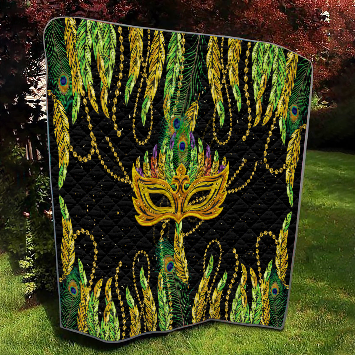 Feather mask Mardi Gras quilt with angled edges, black background and gold mask over peacock feathers