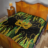Feather mask Mardi Gras quilt on bed, black with green and yellow feathers and gold mask