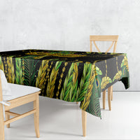Green leaf and peacock feather patterned tablecloth draped over dining table