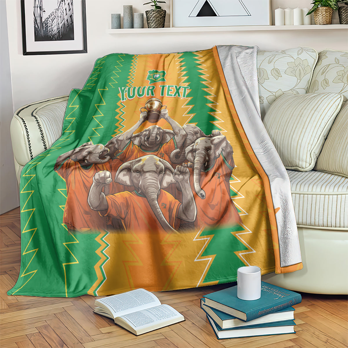 Football blanket draped on couch: green and orange zigzags with crest and elephants