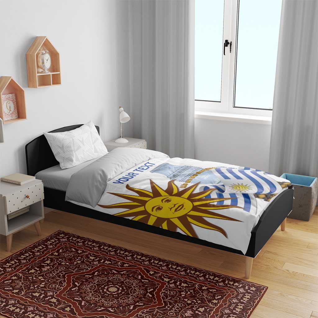 White bedding set on black bed frame; blue-striped flag and sun face printed on duvet