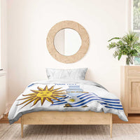 White bedding set on wooden bed; blue striped flag and sun face graphic on duvet
