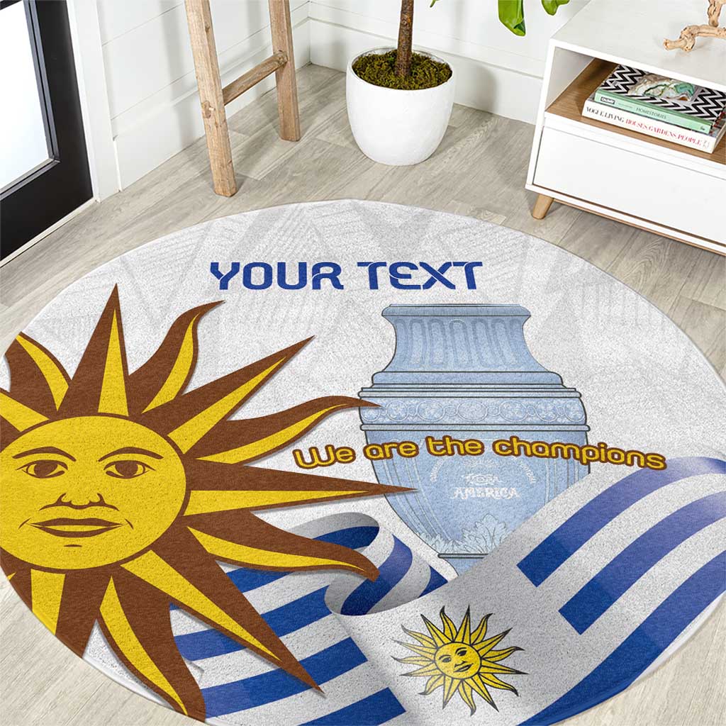Round rug with Uruguay sun graphic, blue stripes, and 'We are the champions' text