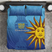 Blue bedding set on floor with yellow sun-face design and 'Your Text' on the duvet