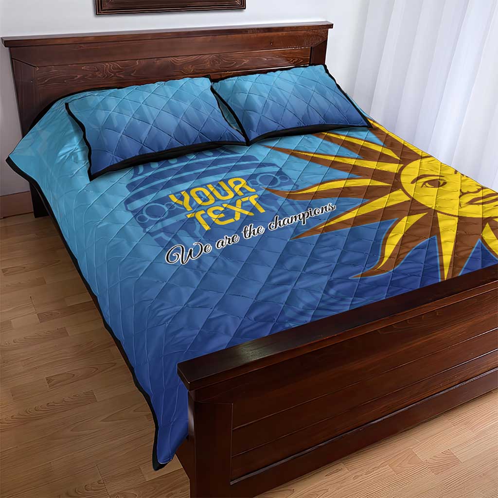 Blue quilt bed set with two pillows, yellow sun graphic and 'We are the champions' text