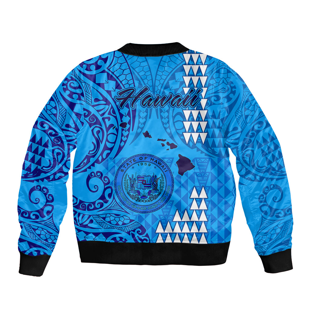 Blue bomber jacket back with large Hawaii crest and tribal pattern, black ribbed hem and cuffs
