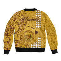 Gold bomber jacket back with Hawaiian crest, swirl tribal patterns, ribbed hem