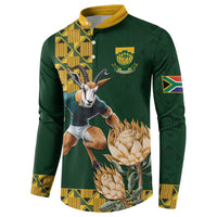 Green rugby button sweatshirt with animal-and-protea graphic, yellow trim, and sleeve flag patch