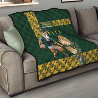 Green rugby quilt spread on gray sofa with yellow geometric edge and Springbok graphic