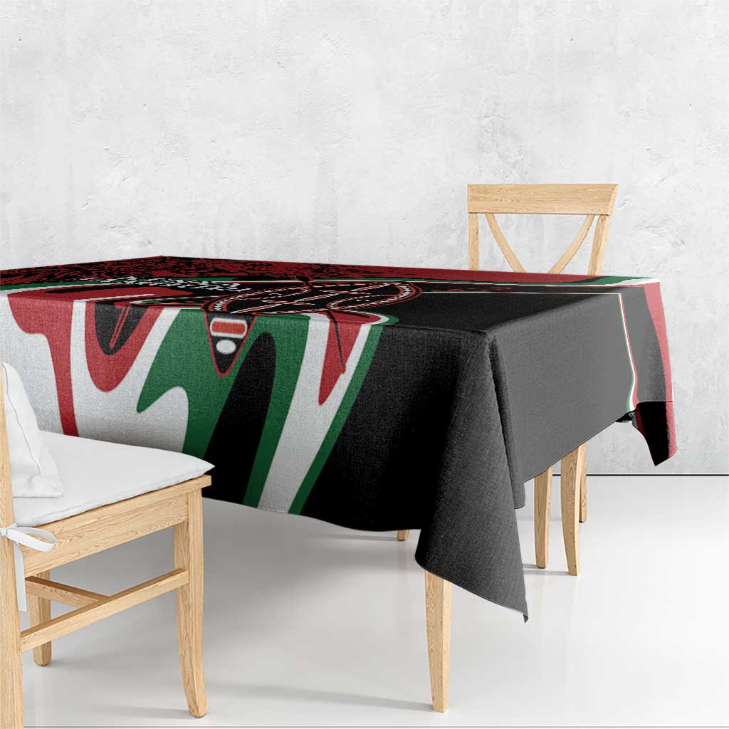 Red and black tablecloth with green and white geometric tribal design, neatly overhanging edges