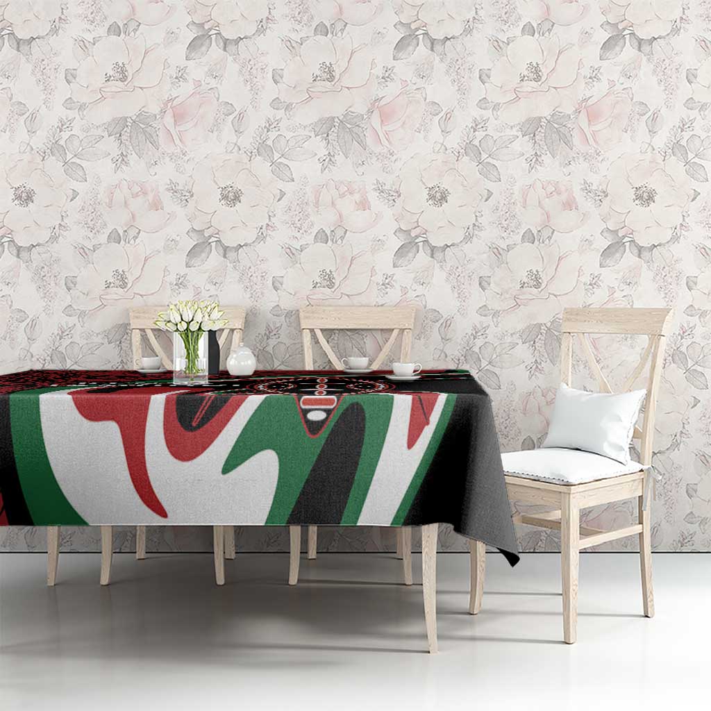 Black, red, green, and white tablecloth with large tribal graphic motif over dining table