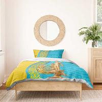 Gold and teal duvet with two pillows featuring gold statue medallion on bed