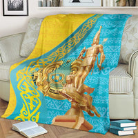 Gold and teal throw blanket with golden warrior artwork draped over sofa back