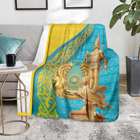Teal and yellow throw blanket with golden warrior figure, shown folded on a seat